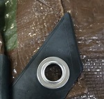 Aluminum grommet on a Brown/Olive Green 8x8 light-duty tarp.